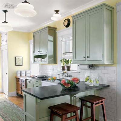 Kitchen with peninsula, yellow walls, and green cabinets.