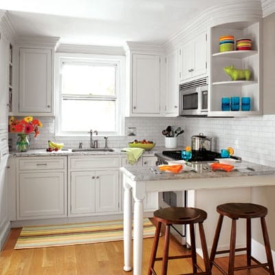 Small kitchen with peninsula and two barstools.