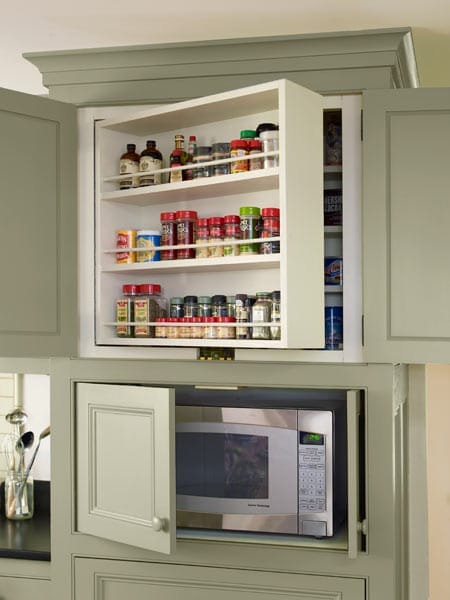 A cabinet hiding a microwave and spice rack