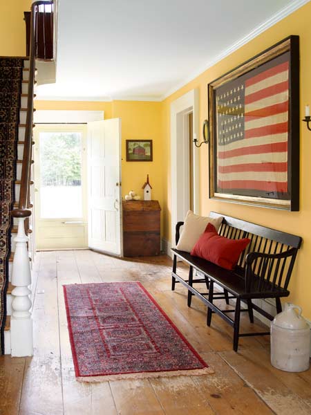 The entryway of the farmhouse with a large American flag on the wall