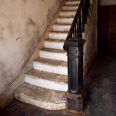 Front hall staircase with hand-carved banister and newel post.