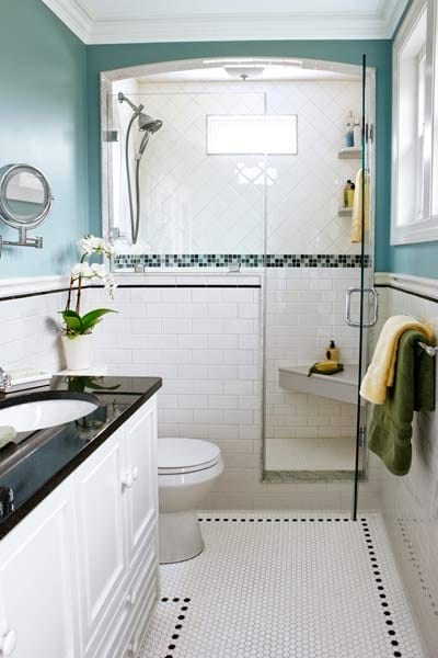 A small bathroom with blue and tiled walls.