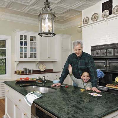 Historic kitchen with embossed metal ceiling and original stove.