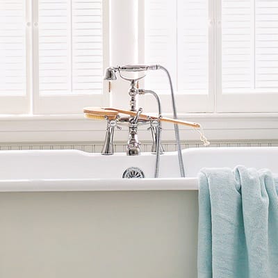 A vintage style Victorian tub with modern faucets.
