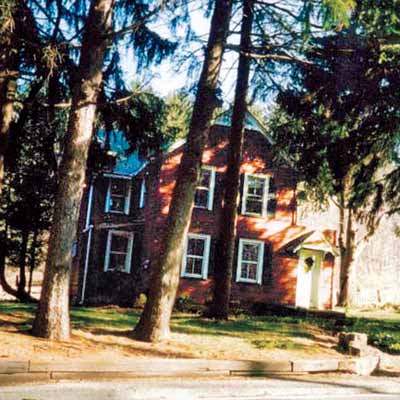 Before photo of the farmhouse with red aluminum siding