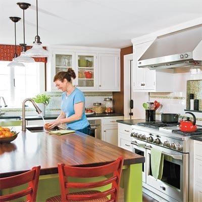 Kitchen after renovation with open layout and wood-topped island.