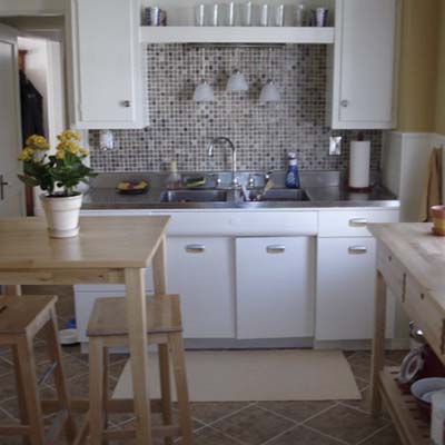 Updated kitchen featuring slate tile backsplash and new faucet installation.