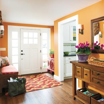 Entryway after renovation featuring warm pumpkin-colored walls.