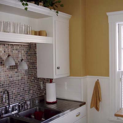 Painted cabinets with pendant lighting and stainless steel switch plates.