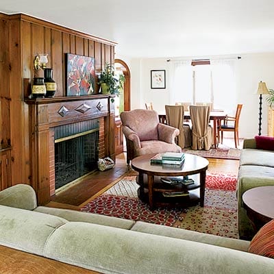Before renovation living room with dark knotty pine fireplace surround.