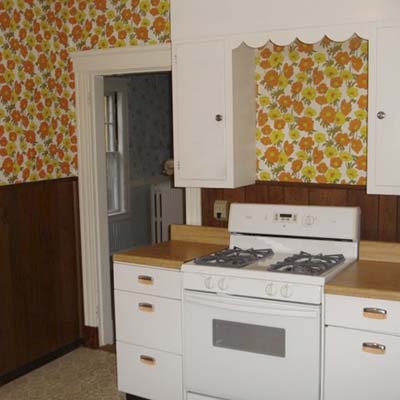 Original stove area with wood paneling before kitchen renovation.