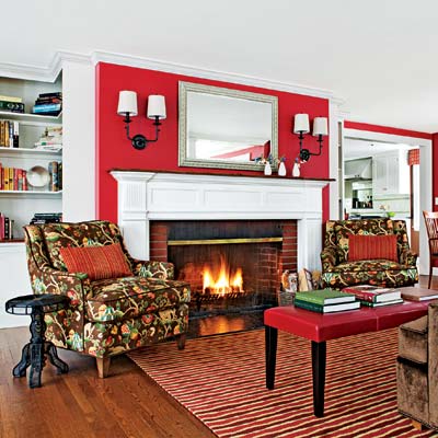 Auburndale house living room after renovation with bold red walls, white trim, and comfortable seating arrangements.