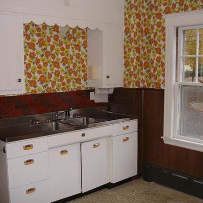 Dated kitchen sink area with scalloped soffit and 1970s wallpaper.