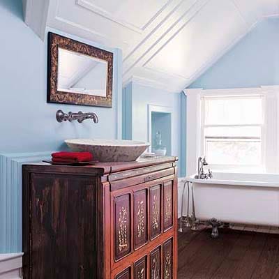 Blue walls in a bathroom with antique vanity.