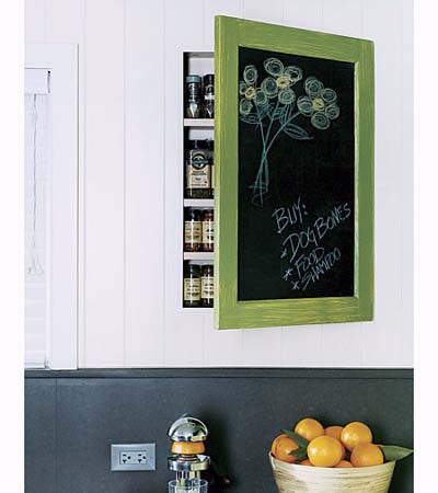 Custom spice cabinet with chalkboard front and green trim mounted on kitchen wall.