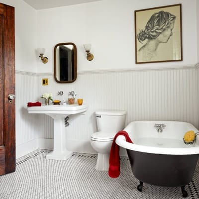 Classic bathroom renovation featuring hex tile flooring and claw-foot tub.