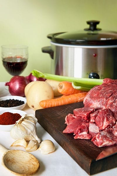 Meat and vegetables in front of a pressure cooker