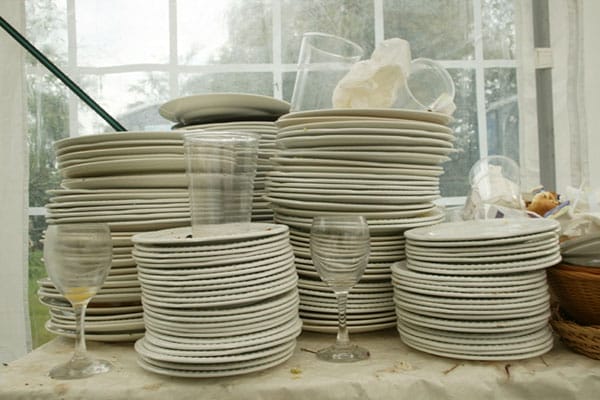 Dirty dishes and cups stacked in piles