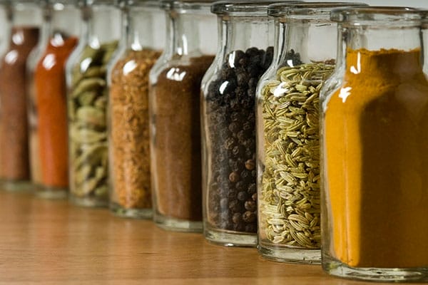 Glass jars full of spices lined up in a row