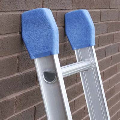 A ladder with ladder mitts at its top leaned against a brick wall.