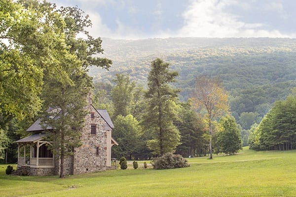 Stone cottage with deep covered porch and slate roof featuring Lookout Mountain views.
