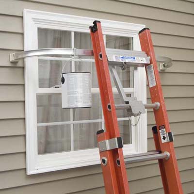 An orange ladder leaned against a window with stabilizer bars.