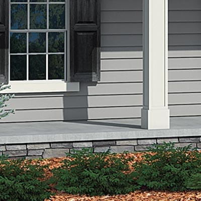 Stone veneer cladding applied to concrete porch foundation.