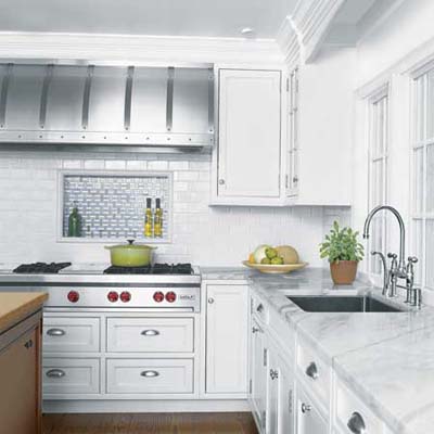 Industrial kitchen featuring four-foot studded steel range hood design.