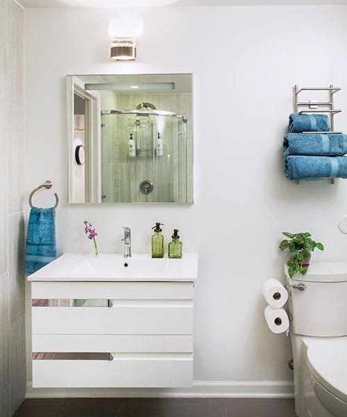 Modern Jack and Jill bathroom with floating vanity, dark vinyl flooring, and hotel-style amenities.