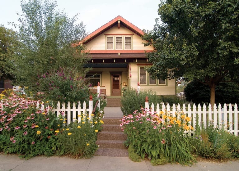 White picket fence in front of Bungalow.