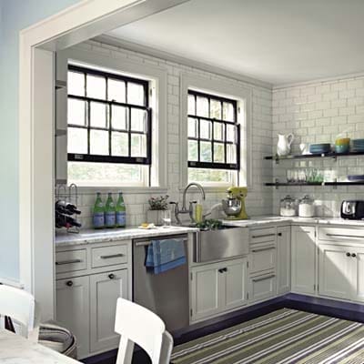 Black window frames and shelving over marble tile subway patterns.