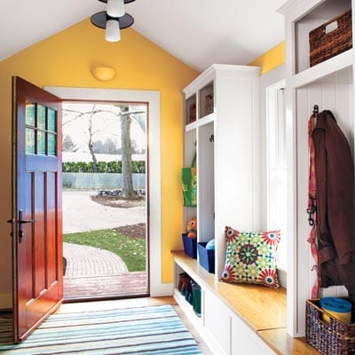 New mudroom addition with storage cubbies, oak bench seat, and large window providing organized transition from outdoors.