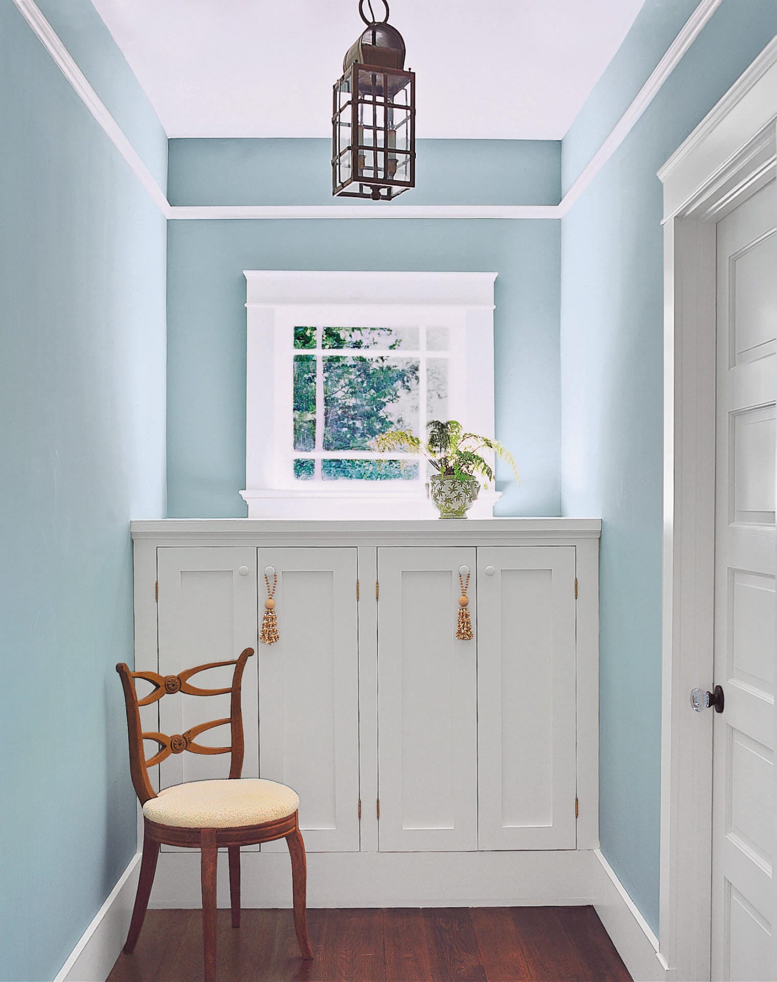 A storage cabinet sitting below a window.
