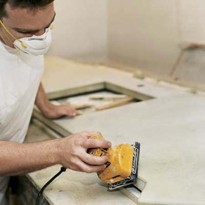 A man using a tool to apply a step-like texture to concrete.