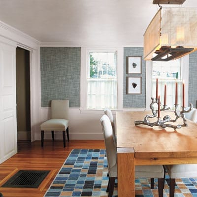 Updated dining room with ivory-painted trim, denim-blue grasscloth walls, and contemporary furnishings complementing traditional architecture.
