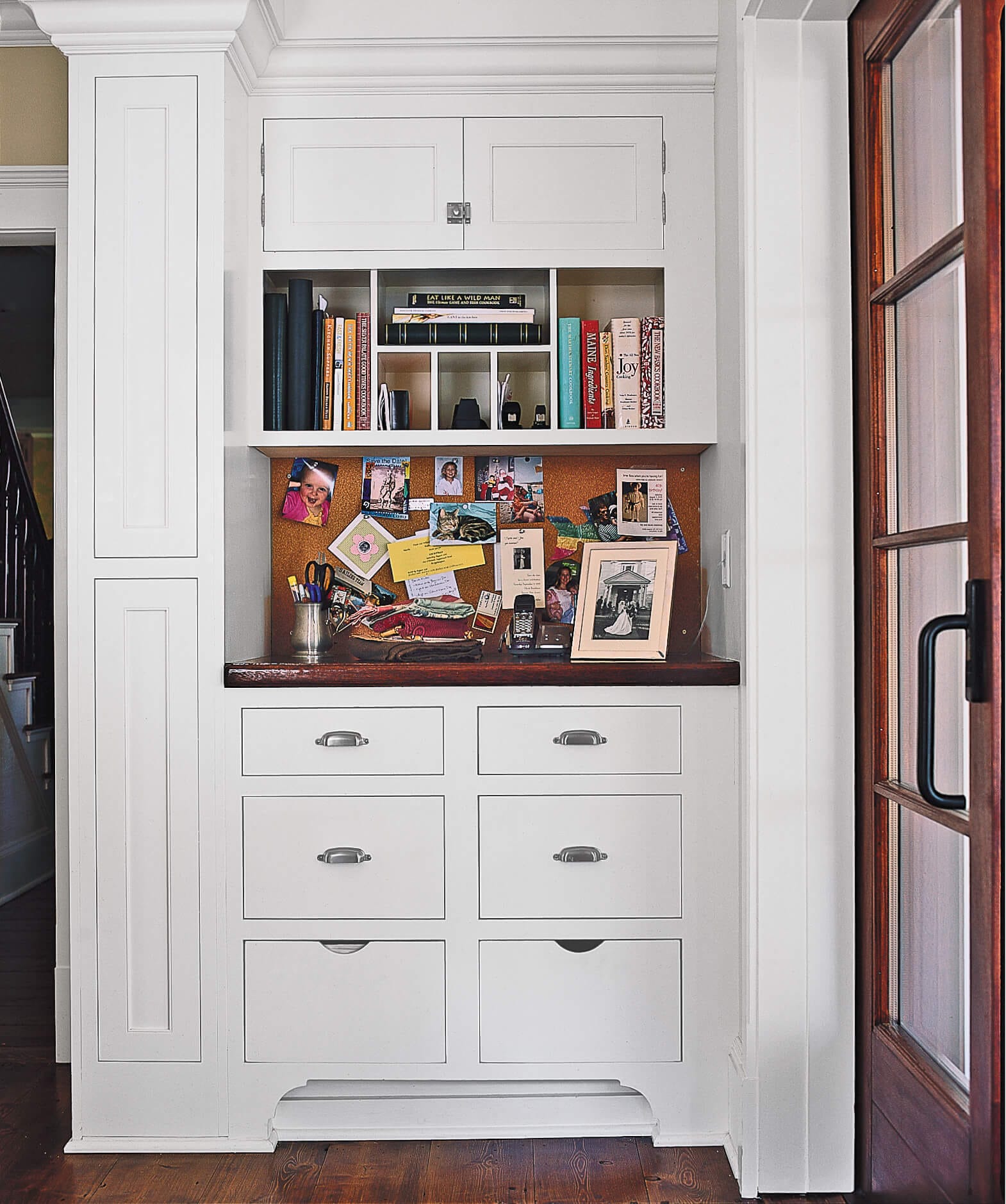A stand up desk with built in drawers and cabinets for storage.