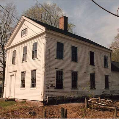 A two-story rundown white house