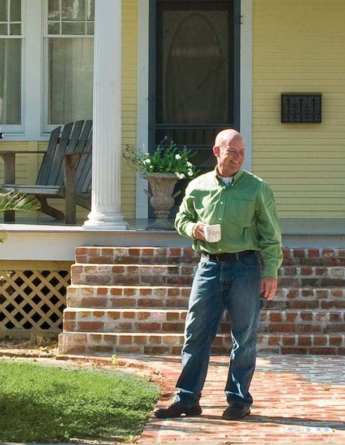 Man standing on salvaged brick walkway.
