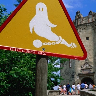 A caution sign showing a ghost restrained by a ball and chain.