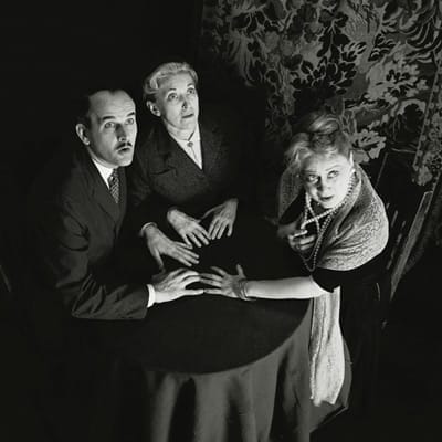 Three people in a haunted home looking up with wonder.