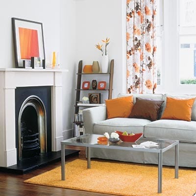 White living room with colorful coordinated accessories and vibrant artwork displays.