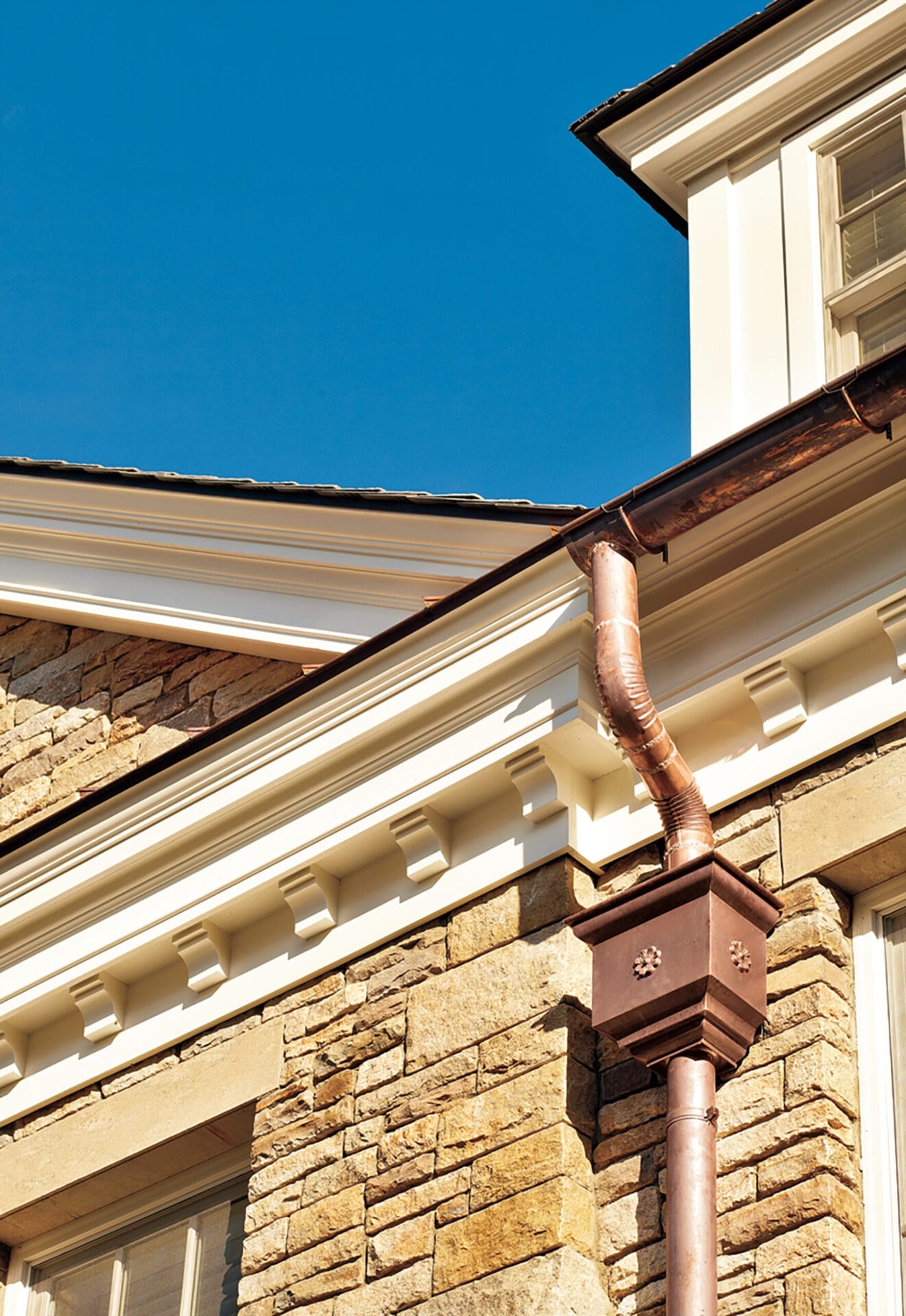 Conductor head on the downspout of a home's gutter.