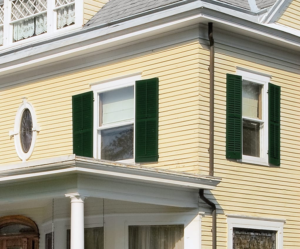 Green shutters on a yellow house.