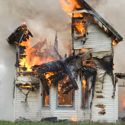 A house burning down after a disaster.