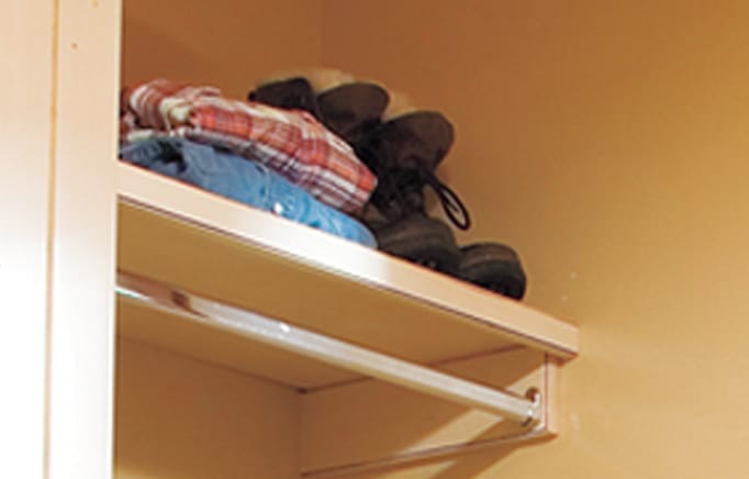 Open shelving above counter displaying folded clothes.