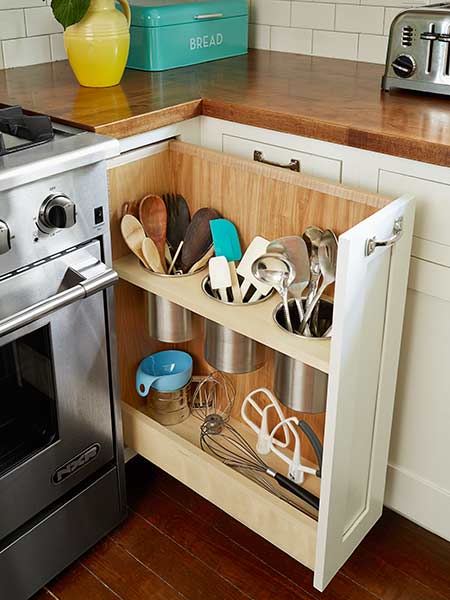 Pull-out corner cabinet utensil storage drawer next to kitchen range.