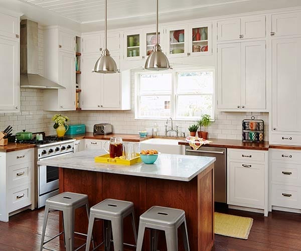 White DIY kitchen cabinets with butcher block counters and maple island.