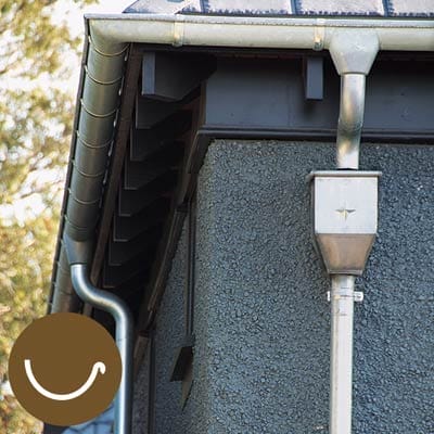 Half-round gutter on the side of a gray house.