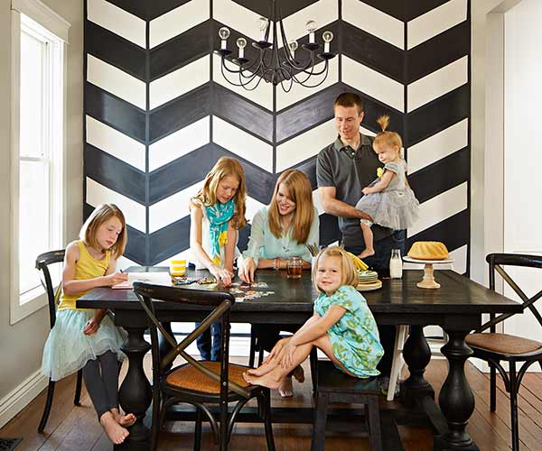 Family of six in renovated farmhouse kitchen with chevron accent wall.