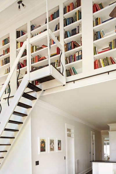 A rolling ladder leading to a loft library